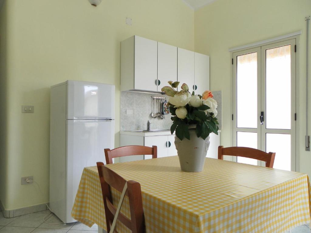 une cuisine avec une table avec un vase de fleurs dessus dans l'établissement Residence Santa Barbara, à San Ferdinando