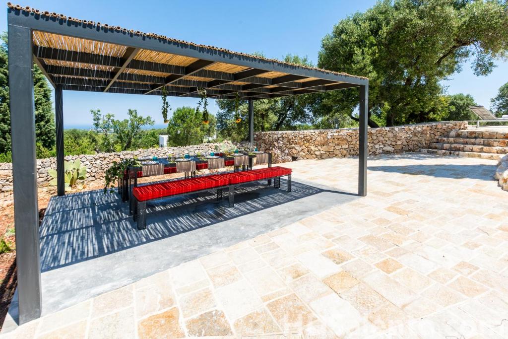 une pergola avec des bancs rouges sur une terrasse dans l'établissement Villa Roberta by HDSalento, à Specchiolla 34 autres photos