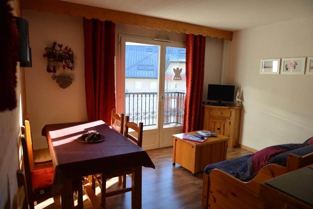un salon avec une table et une chambre avec une fenêtre dans l'établissement Le Grand Panorama 5 Étage Balcon Vue sur La Montagne, à Saint-Gervais-les-Bains