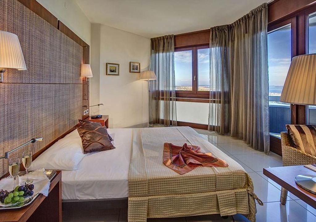 une chambre d'hôtel avec un lit, un bureau et une fenêtre dans l'établissement Hotel Le Tegnue, à Sottomarina