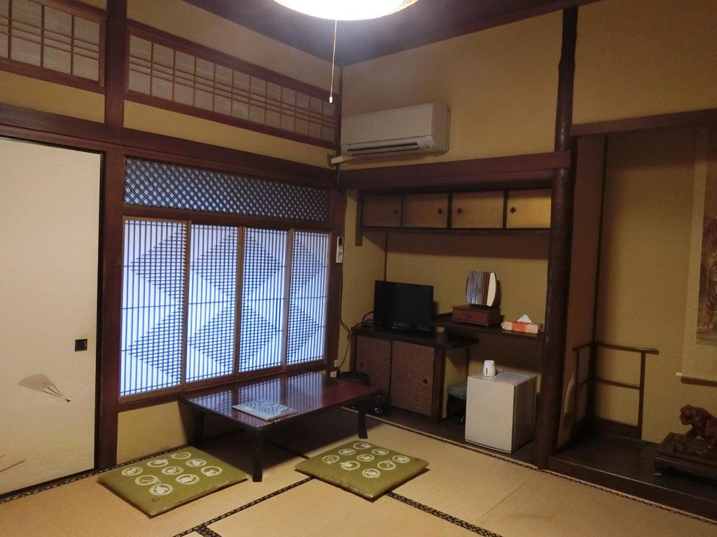 Cette chambre comprend un salon avec une fenêtre et un bureau. dans l'établissement Hoshidekan, à Ise