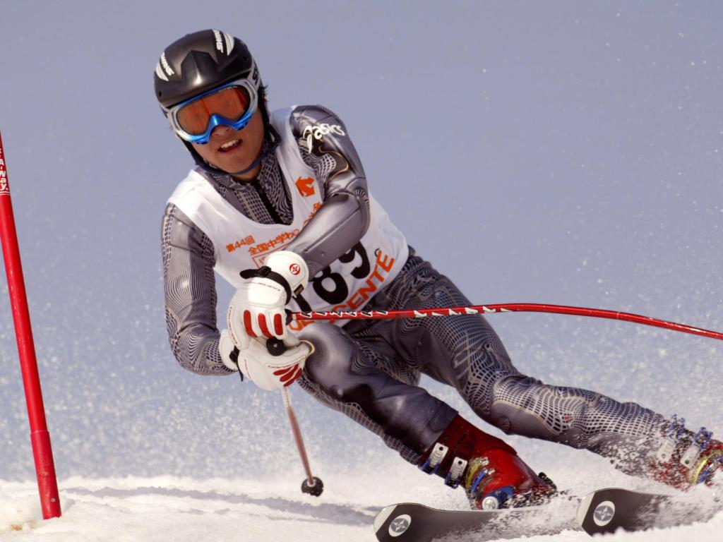 un homme est en train de skier sur une piste enneigée dans l'établissement Yonagoya, à Kami