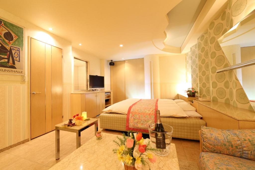 une chambre d'hôtel avec un lit et un salon dans l'établissement Hotel La Siena (Adult Only), à Higashiōsaka
