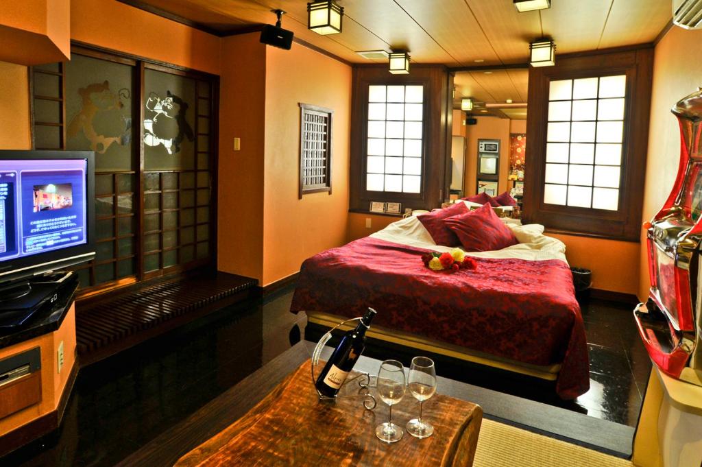 une chambre d'hôtel avec un lit et une télévision dans l'établissement Hotel Omochabako (Love Hotel), à Kurume