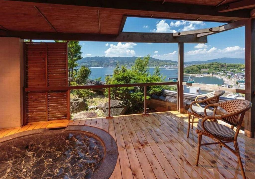 d'une terrasse avec un bain à remous et des chaises sur un balcon. dans l'établissement Wano Resort Hazu, à Gamagori