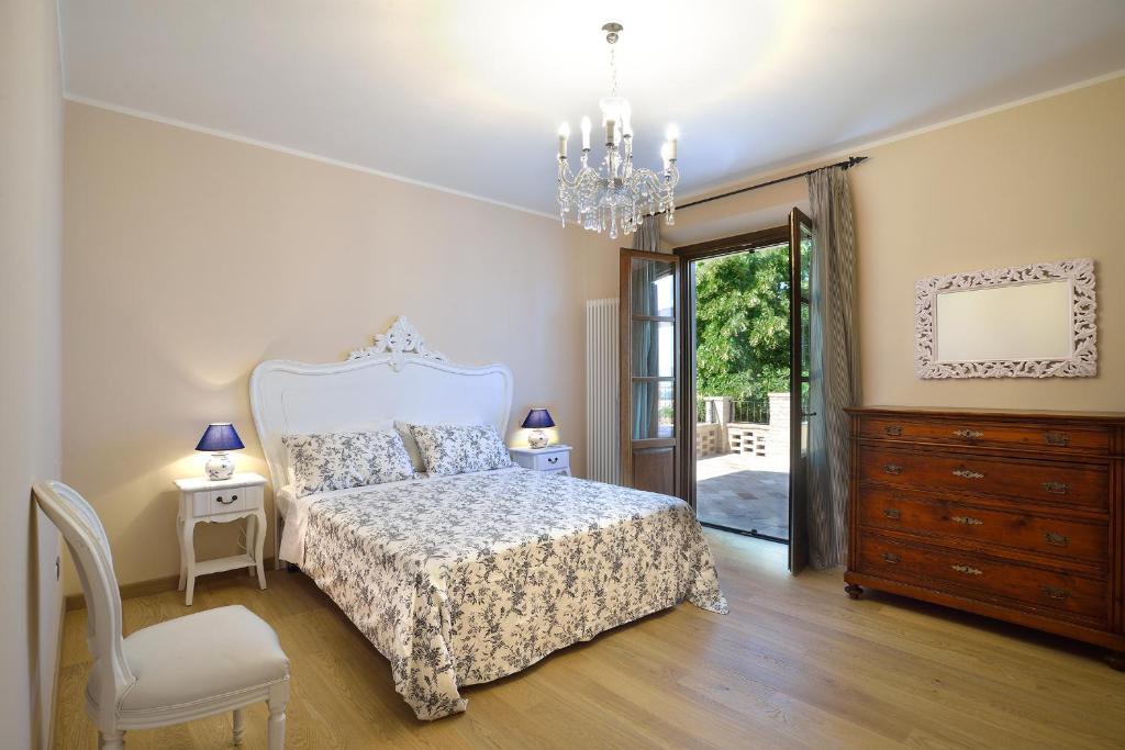 une chambre avec un lit et un lustre dans l'établissement Villa Santa Maria Deruta, à Deruta