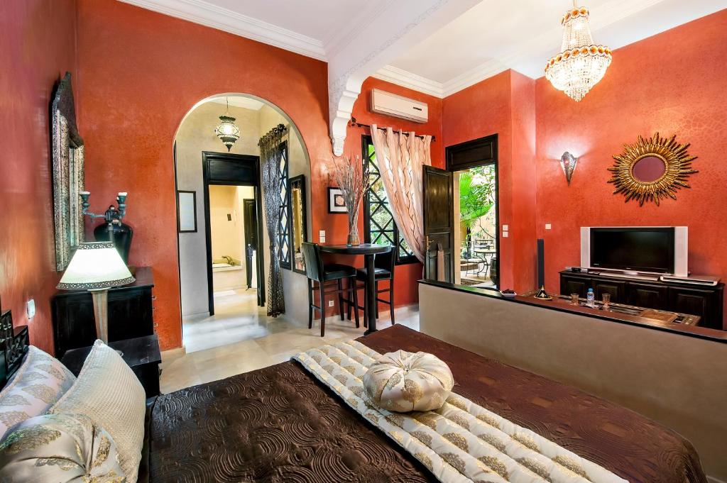 une chambre avec des murs orange et un canapé et une table dans l'établissement Riad Soleil D'orient, à El Jadida