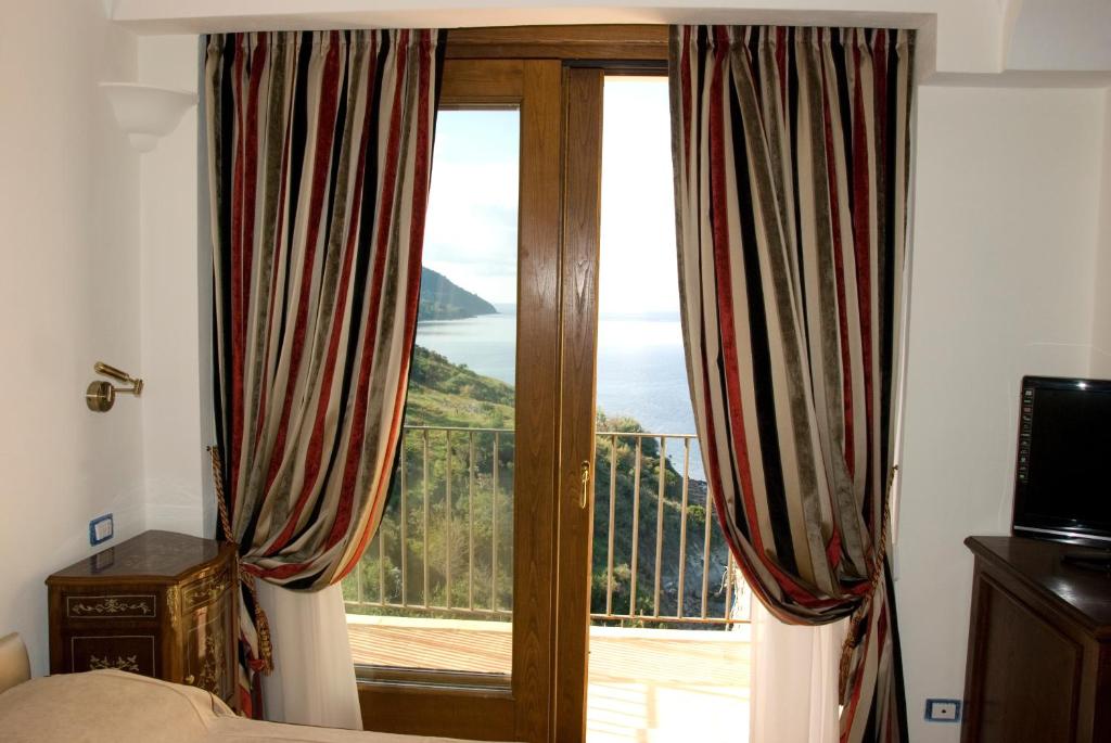- une chambre avec une porte coulissante en verre offrant une vue dans l'établissement San Francesco Resort, à Agropoli