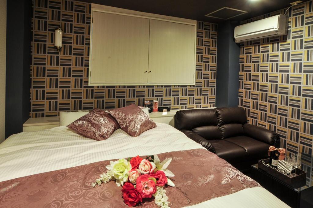 une chambre avec un lit avec des fleurs dessus dans l'établissement Hotel Cube (Love Hotel), à Kitakyūshū