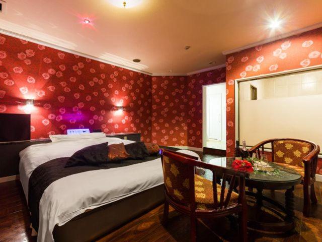 une chambre avec un lit, une table et un miroir dans l'établissement Hotel TiAMO (Love Hotel), à Kitakyūshū