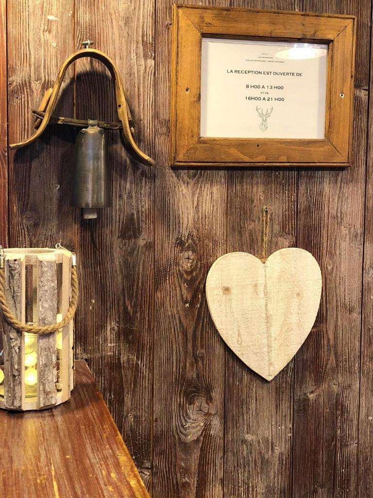 un mur en bois avec un cœur accroché dessus dans l'établissement Hôtel Les Trappeurs, aux Orres