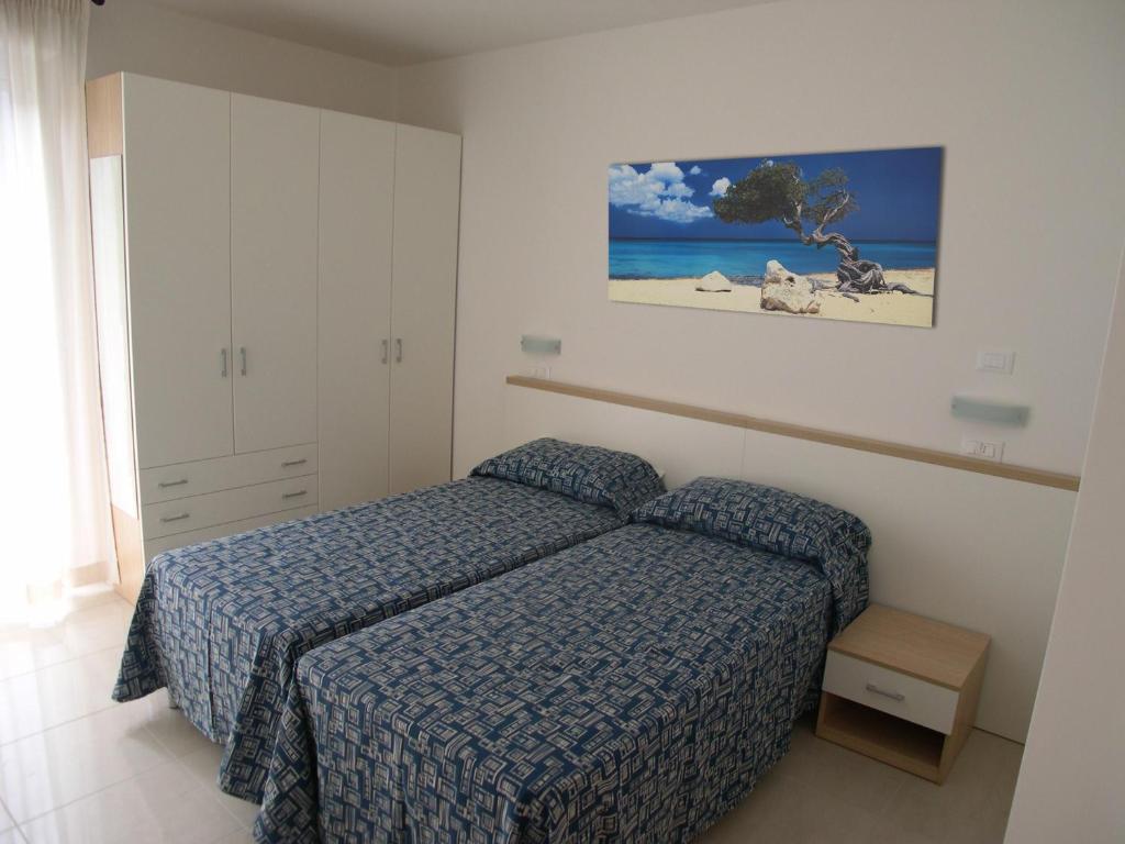 une chambre avec un lit et une photo de plage dans l'établissement Residence I Delfini, à Cupra Marittima 46 autres photos