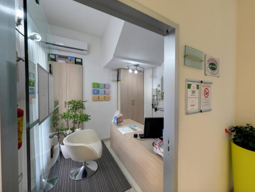 un bureau avec une chaise blanche dans une pièce dans l'établissement Residence Il Tulipano, à Riccione