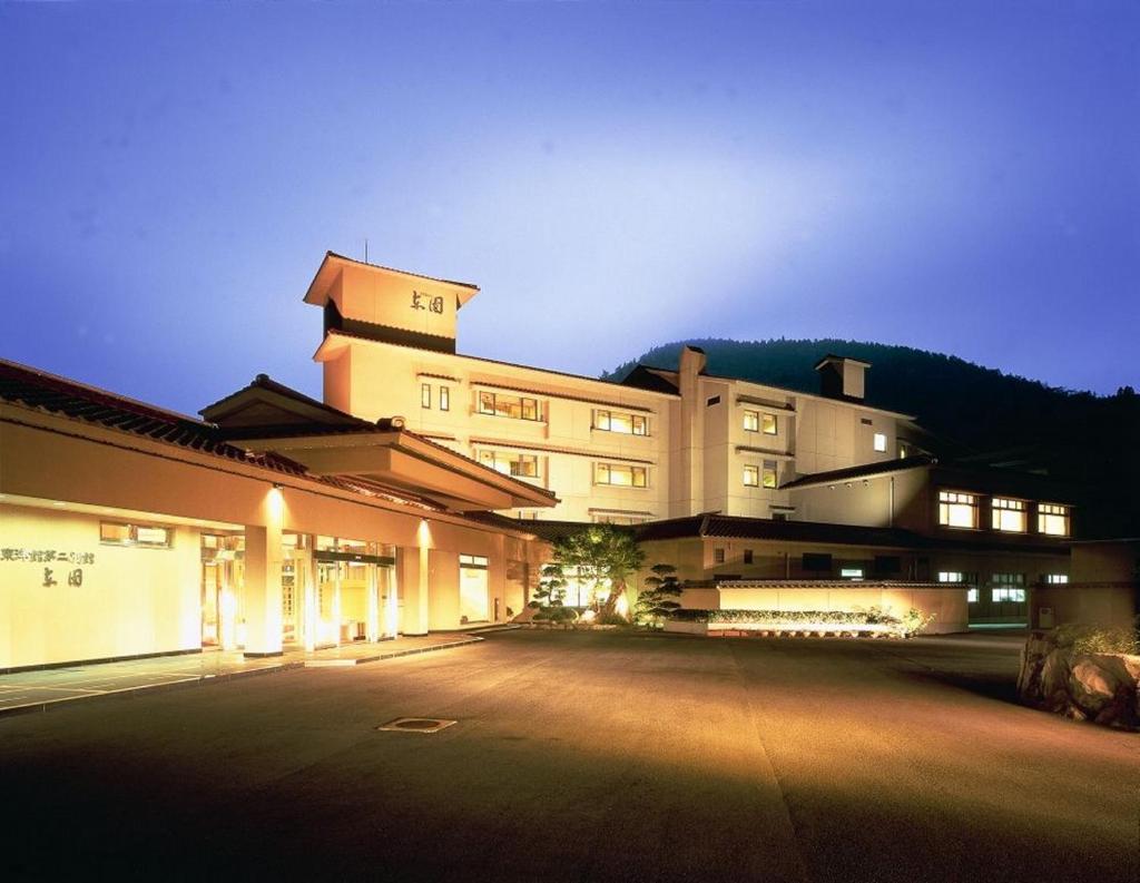Un grand bâtiment est éclairé la nuit. dans l'établissement Azumaen, à Unzen