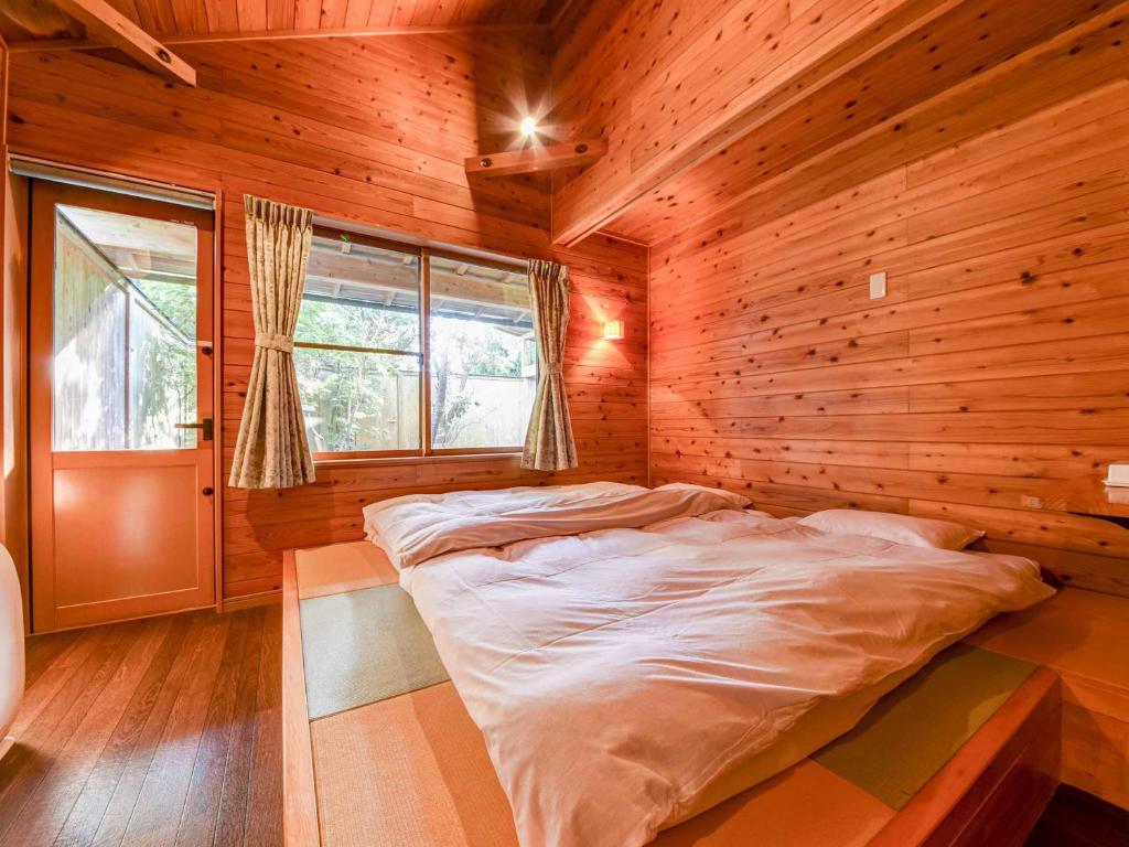 une chambre avec un lit dans une pièce en bois dans l'établissement Spa&Resort Kujukuri Taiyou-no-sato, à Chosei