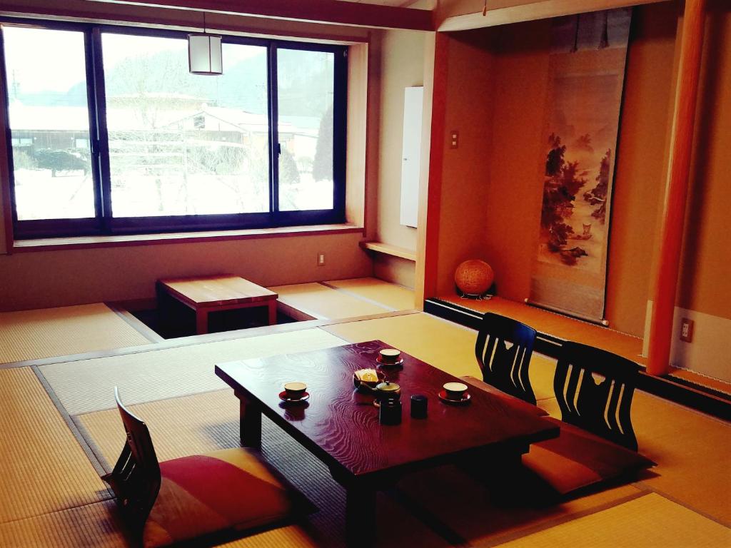 une pièce avec une table, des chaises et une fenêtre dans l'établissement Ryokan Yamakanoyu, à Kiso