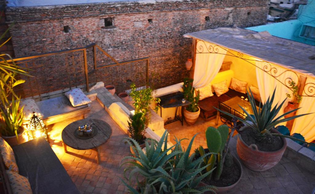 - une vue sur la terrasse agrémentée de plantes et d'un canapé dans l'établissement Riad Dar Arsama, à Fès
