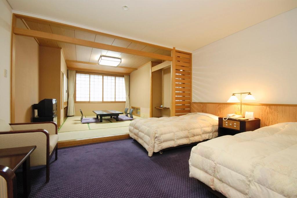une chambre d'hôtel avec deux lits et une fenêtre dans l'établissement Noboribetsu Sekisui Tei, à Noboribetsu