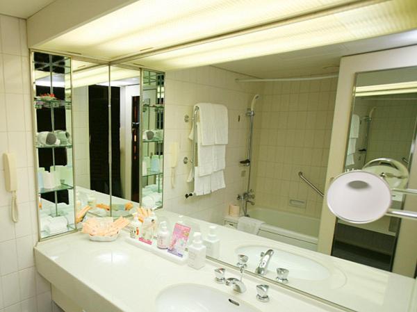 une salle de bain avec un lavabo et un grand miroir dans l'établissement Izumigo Kiyosato Kogen Hotel, à Hokuto 12 autres photos