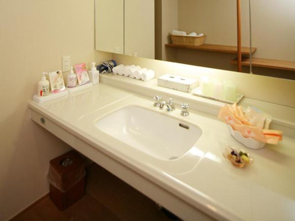 un comptoir de salle de bain avec un lavabo et un miroir dans l'établissement Izumigo Kiyosato Kogen Hotel, à Hokuto