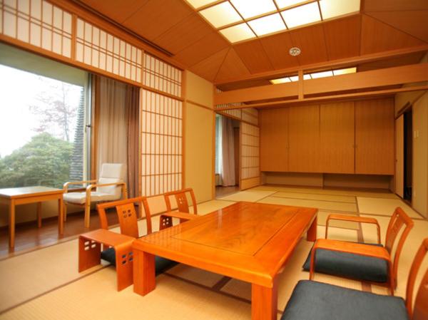 une grande pièce avec une table et des chaises en bois dans l'établissement Izumigo Kiyosato Kogen Hotel, à Hokuto