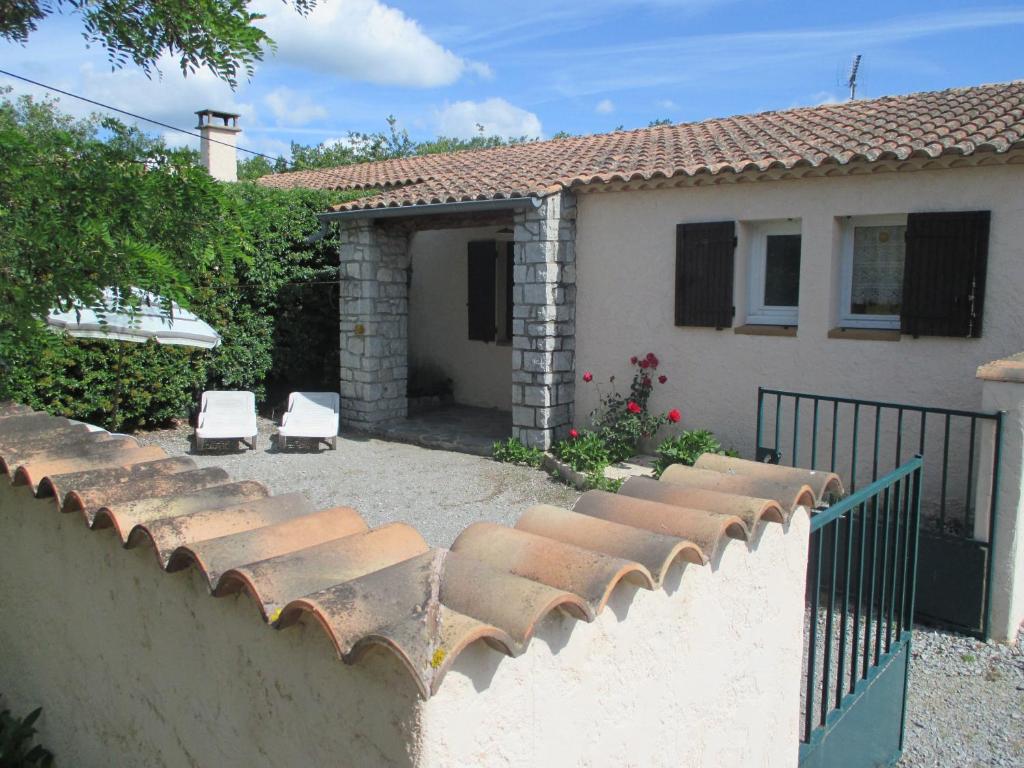 une maison avec deux chaises blanches et une clôture dans l'établissement Village de gites Le Frigoulet, à Balazuc