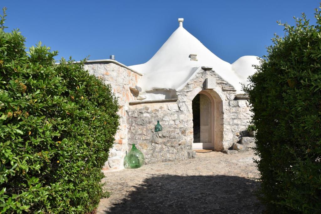 un petit bâtiment en pierre avec une église avec un toit dans l'établissement Trullo Happiness, à Ostuni