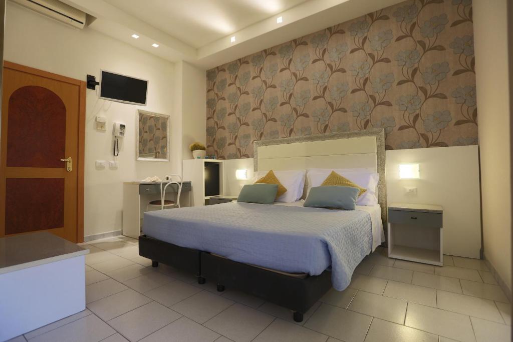 une chambre avec un grand lit avec des oreillers bleus dans l'établissement ELISABETTA hotel, à Cesenatico 21 autres photos