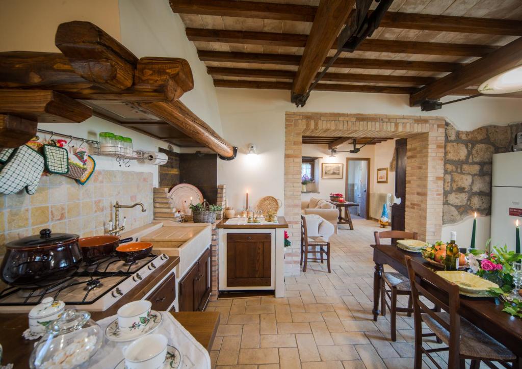 une grande cuisine avec des plafonds en bois et un plan d'étage ouvert dans l'établissement Villa I Calanchi Di Civita, à Bagnoregio