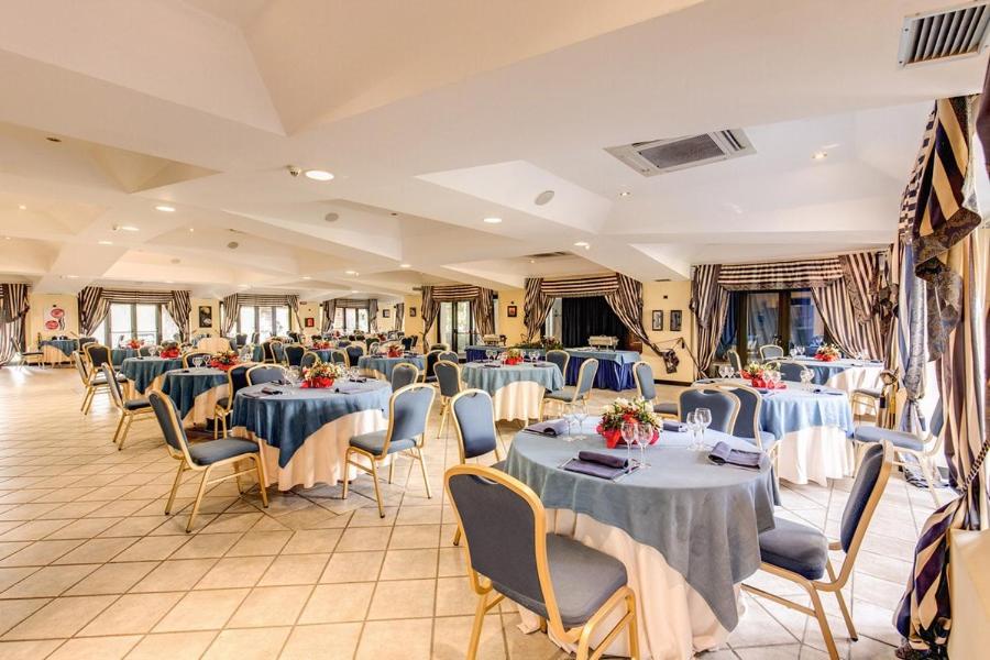 une salle de banquet avec des tables et des chaises bleues dans l'établissement Marina Club Hotel, à Baia Domizia