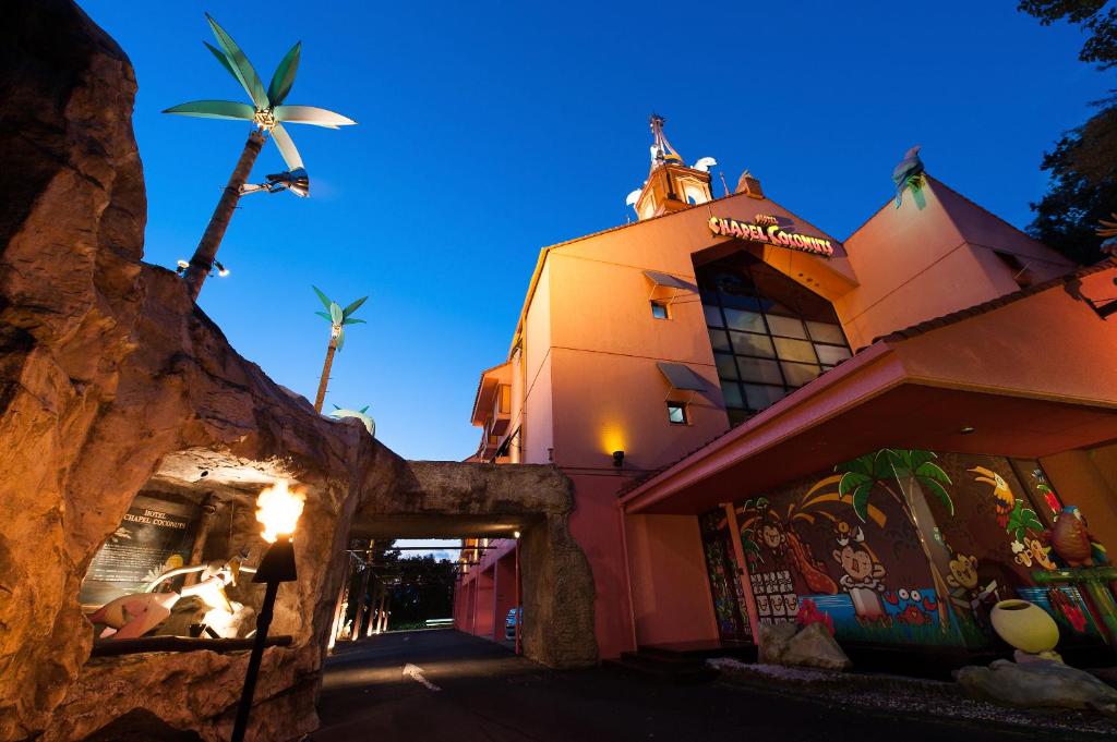 un bâtiment avec un palmier devant dans l'établissement ホテル チャペルココナッツ 亀山, à Kameyama