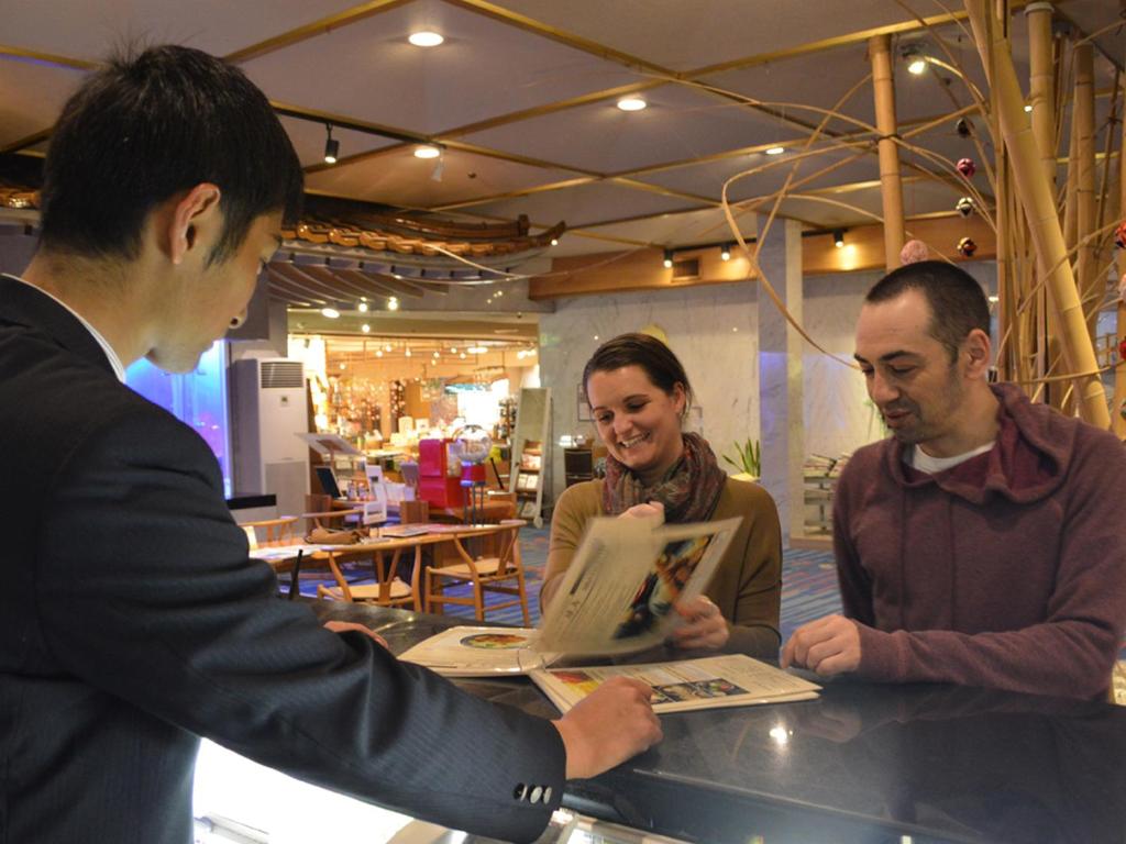 Un groupe de personnes debout autour d'un comptoir dans l'établissement Shimoda Yamatokan, à Shimoda 37 autres photos