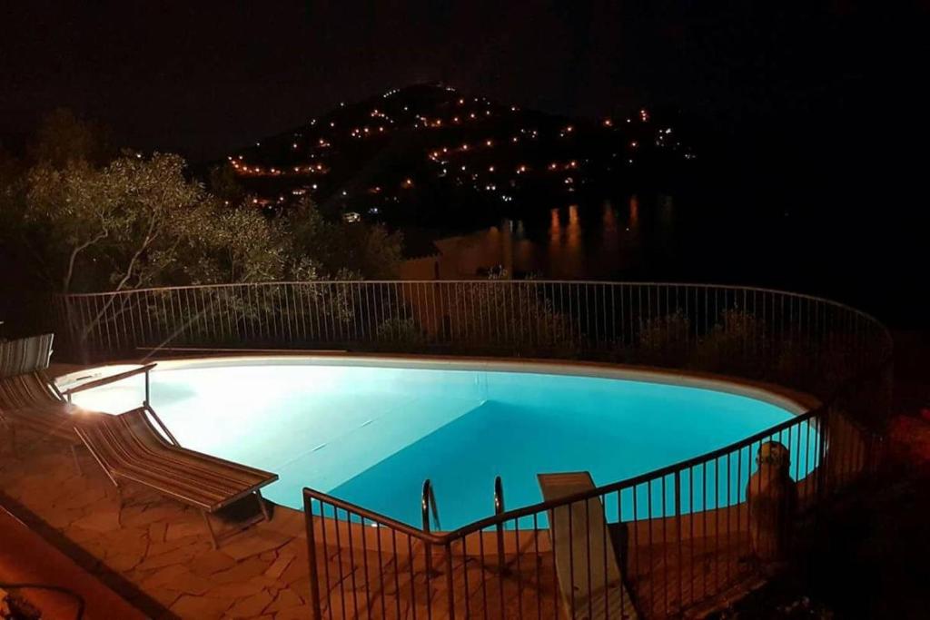 - une grande piscine bleue la nuit éclairée dans l'établissement Villa panoramica tra suggestive notti stellate., à Torre delle Stelle 19 autres photos