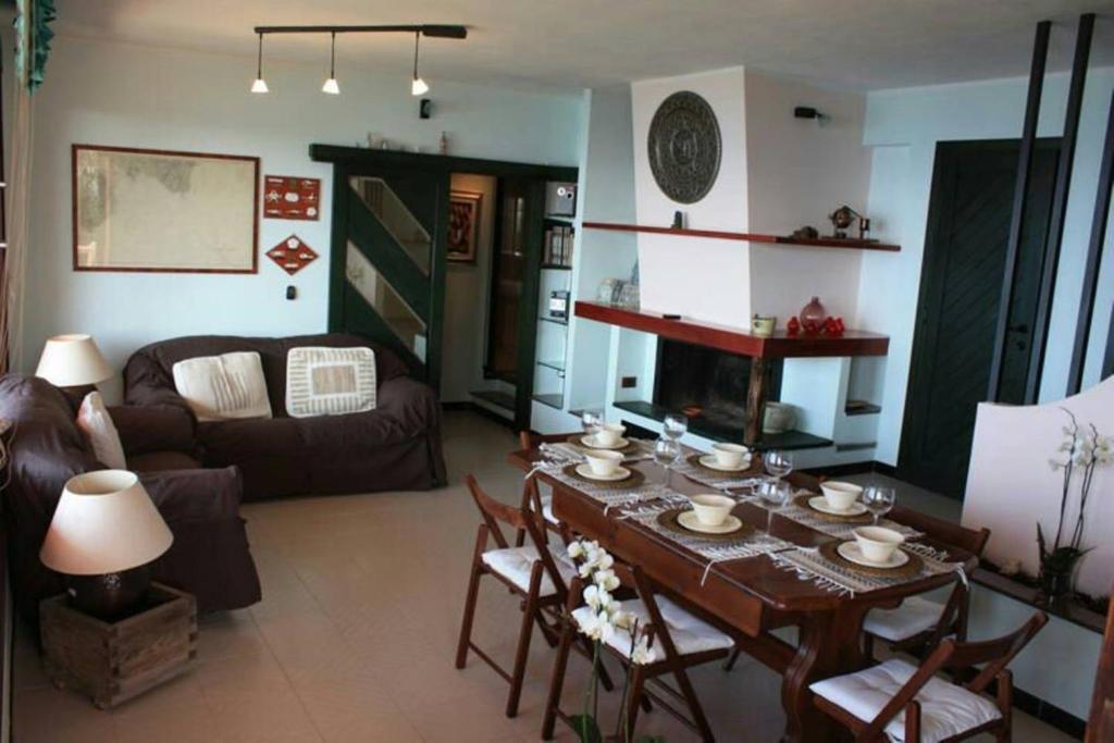 un salon avec une table et une cheminée dans l'établissement Villa panoramica tra suggestive notti stellate., à Torre delle Stelle