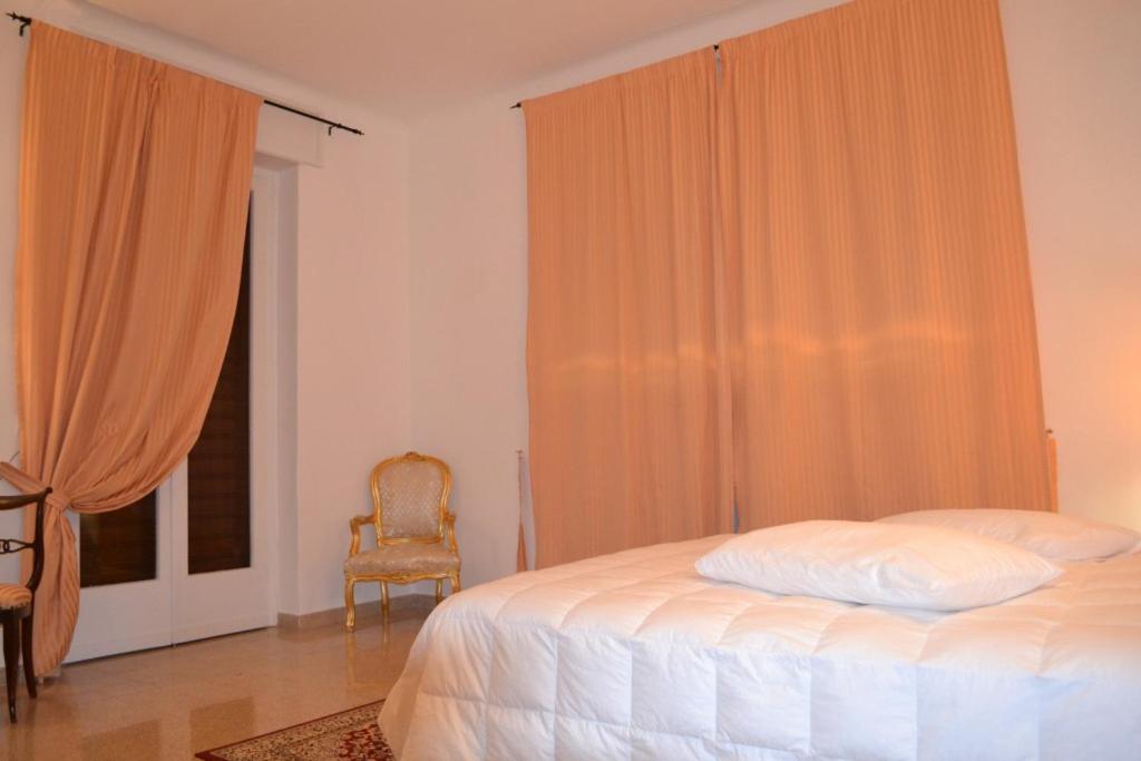 une chambre avec un lit, une chaise et une fenêtre dans l'établissement Villa panoramica con piscina, à Fasano 16 autres photos