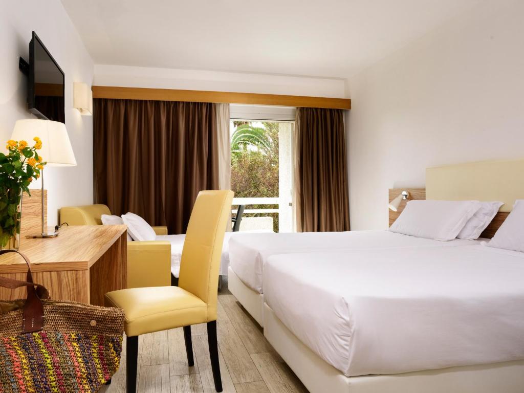 une chambre d'hôtel avec un grand lit et un bureau dans l'établissement TH Simeri - Simeri Village, à Simeri Mare