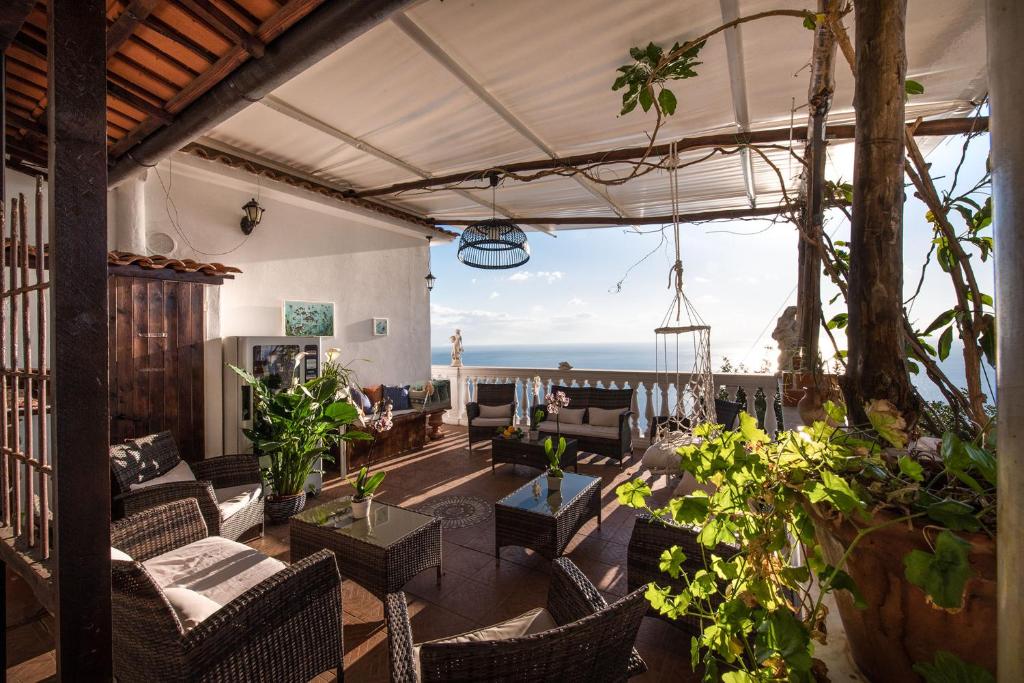 d'une terrasse avec des chaises et des tables et une vue sur l'océan. dans l'établissement Villa Gioiello, à Amalfi