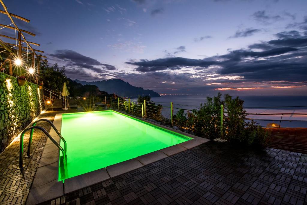 - une piscine verte sur un balcon la nuit dans l'établissement Villa Gioiello, à Amalfi
