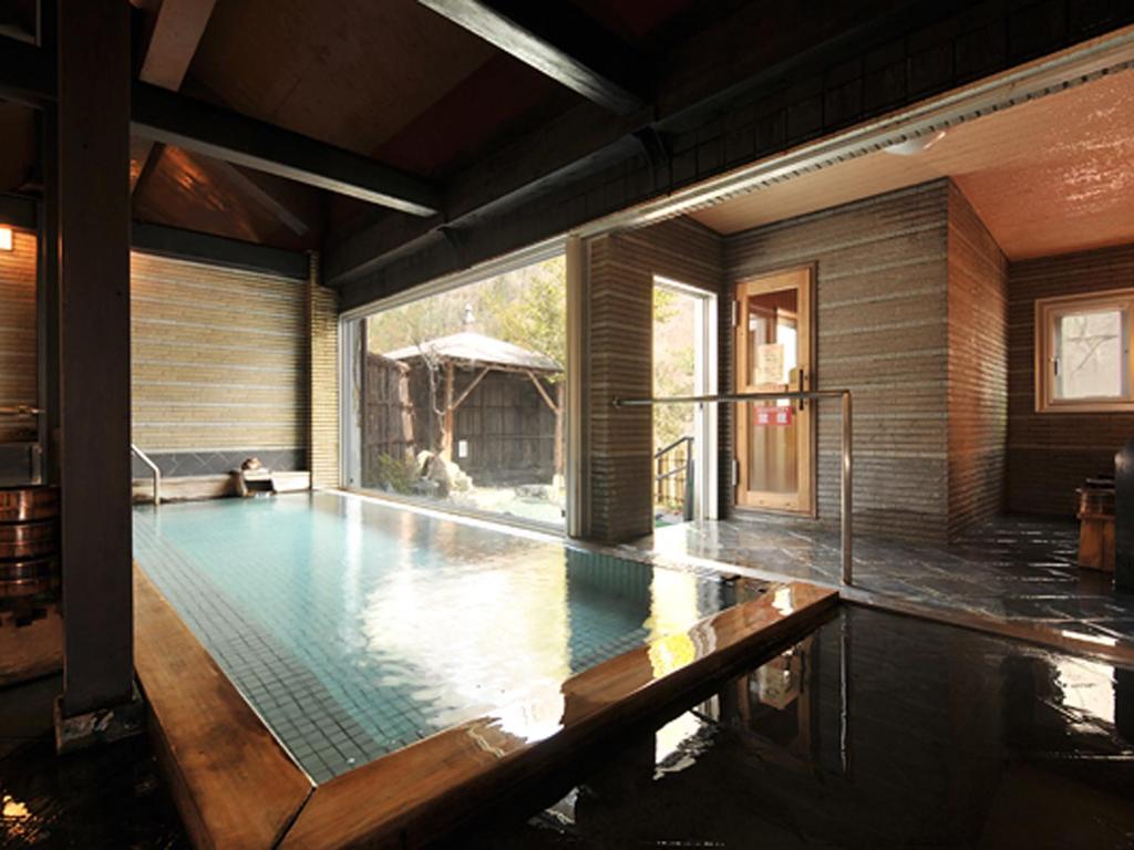 - une piscine dans une maison avec une grande fenêtre dans l'établissement Ginshotei Awashima, à Numata