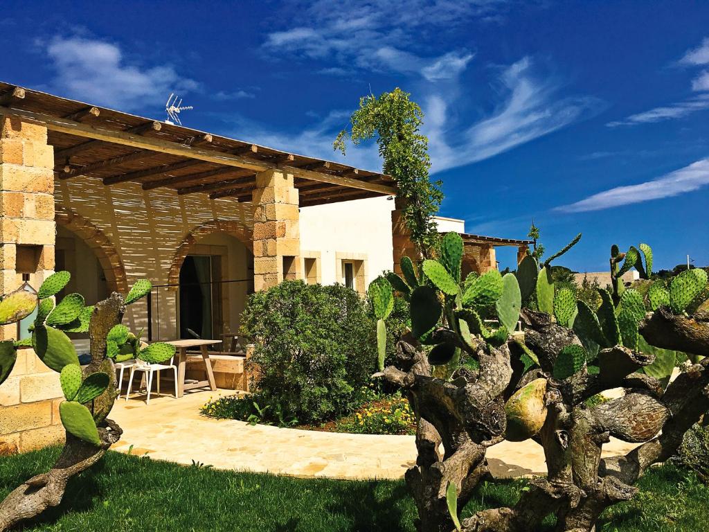 un jardin avec une maison en pierre avec un cactus dans l'établissement Agriturismo Vigna Corallo, à Otrante