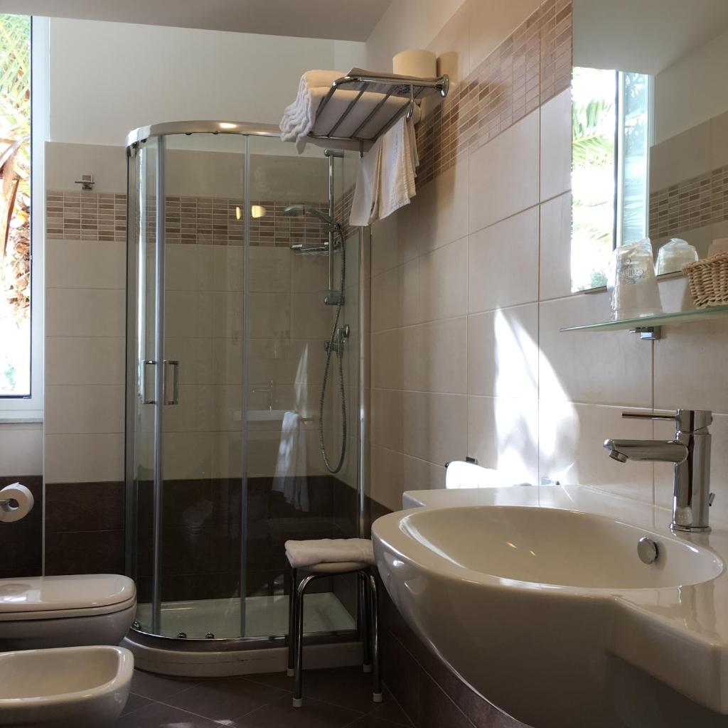 une salle de bain avec douche, lavabo et toilettes dans l'établissement Hotel Villa Igea, à Alassio