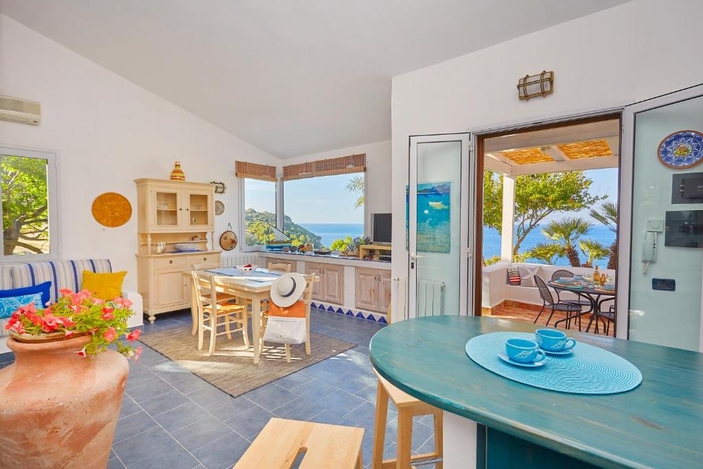 une cuisine et un salon avec une table et des chaises dans l'établissement Villa Ginestra - Scopello-Villas, à Scopello