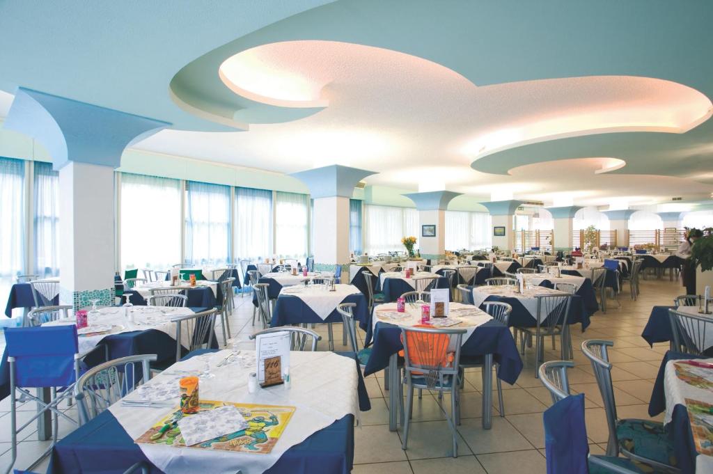 d'une salle à manger avec des tables, des chaises et des plafonds. dans l'établissement Hotel Zenith, à Cervia