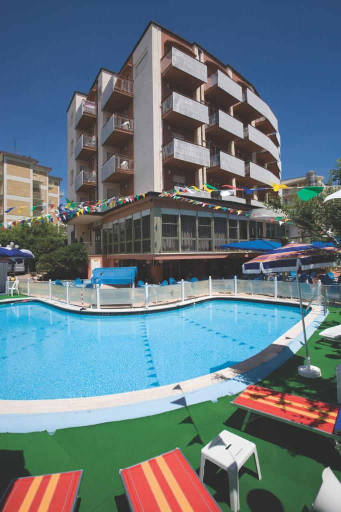 une grande piscine devant un immeuble dans l'établissement Hotel Zenith, à Cervia