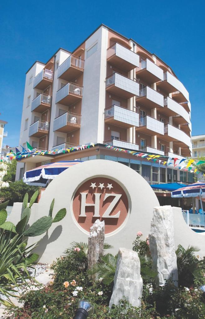 un grand bâtiment avec une enseigne devant dans l'établissement Hotel Zenith, à Cervia