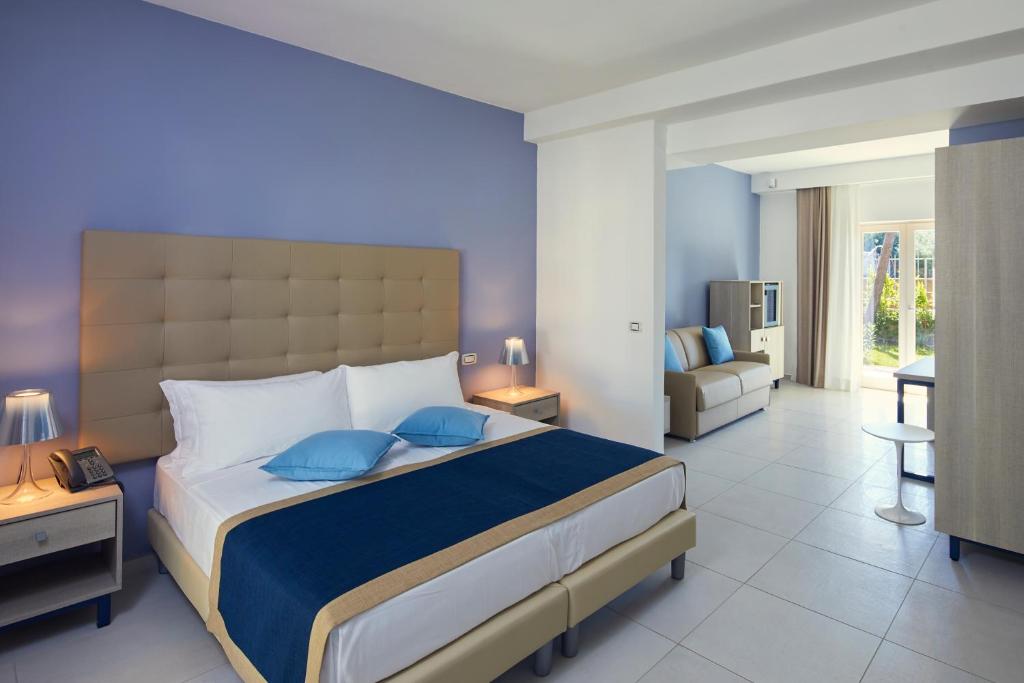 une chambre avec un grand lit et un salon dans l'établissement TUI BLUE Tropea, à Santa Domenica