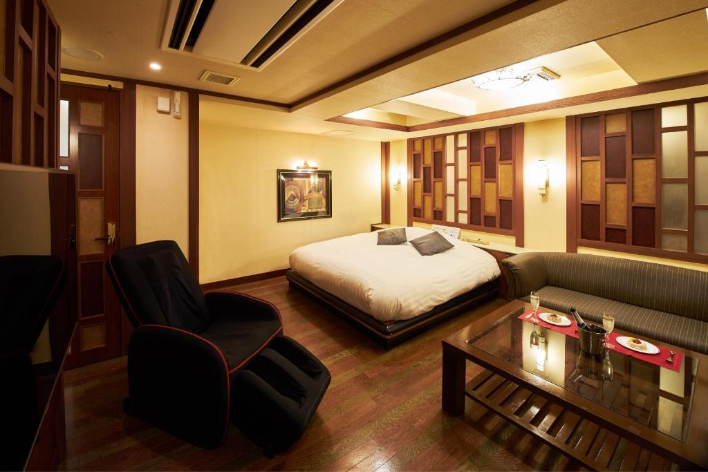 une chambre d'hôtel avec un lit et un canapé dans l'établissement Hotel AQUA Blue Yokosuka (Adult Only), à Yokosuka
