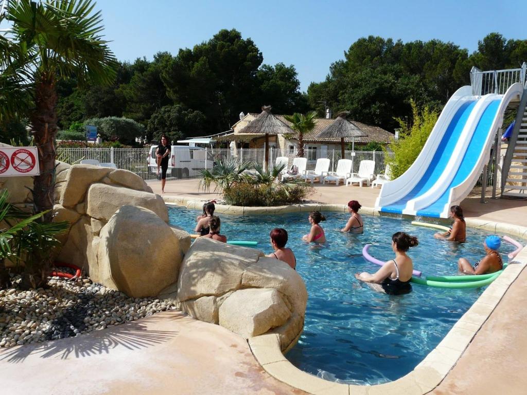 un groupe de personnes jouant dans une piscine dans l'établissement Camping La Montagne, à Sorgues