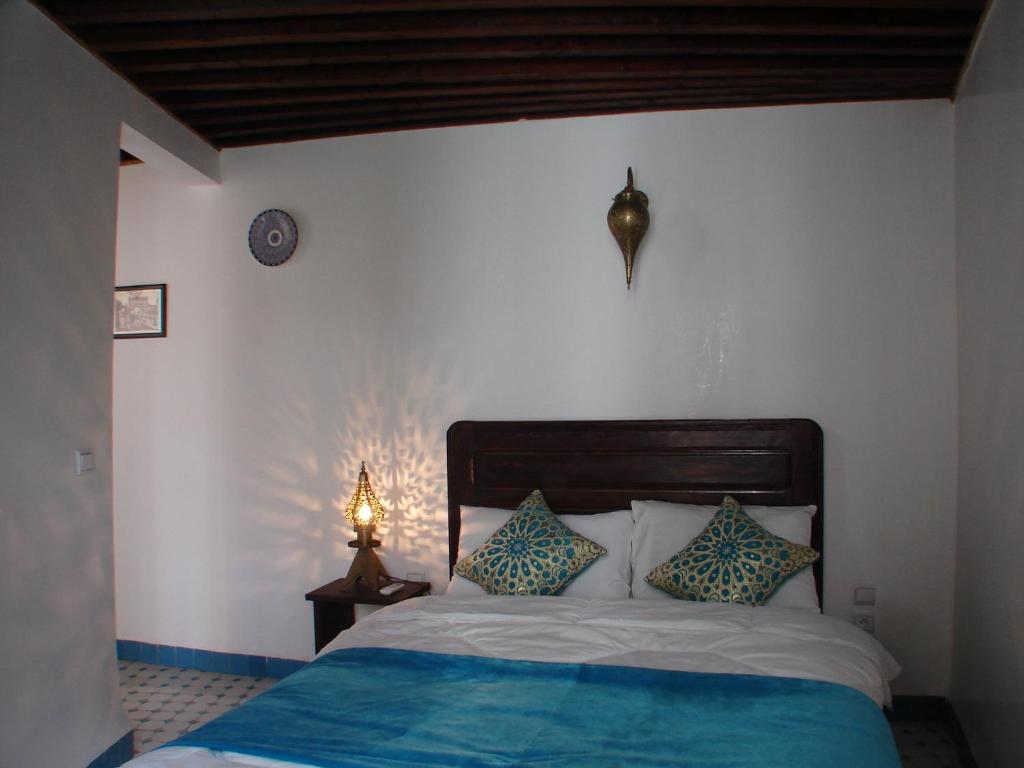 une chambre avec un lit et une horloge au mur dans l'établissement Riad Sheryne Fes, à Fès
