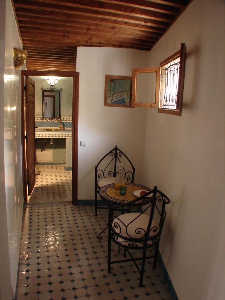 une chambre avec une table, une chaise et une table dans l'établissement Riad Sheryne Fes, à Fès